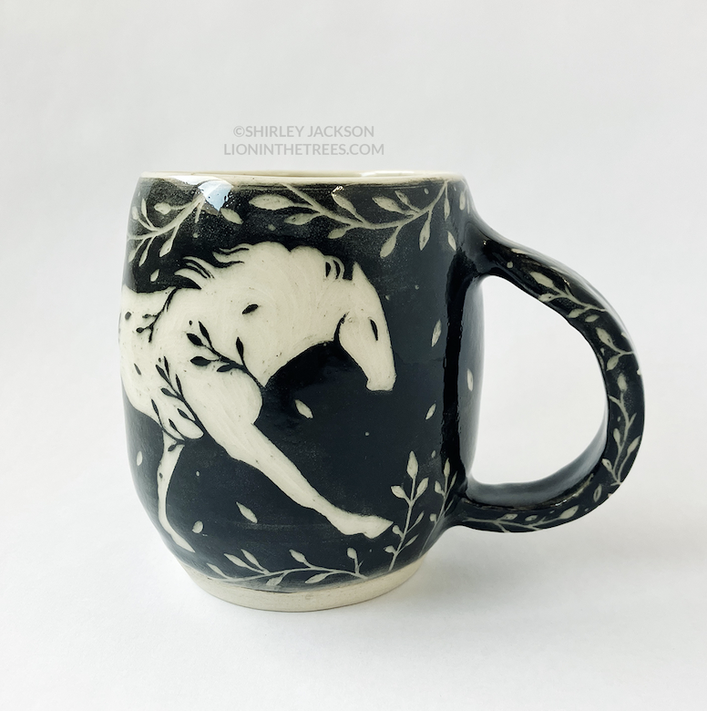 Photo of my black sgraffito mug that features my running horse motif.