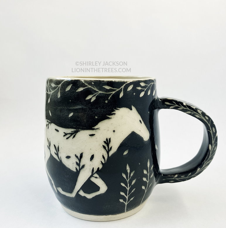 Photo of my black sgraffito mug that features my running horse motif.