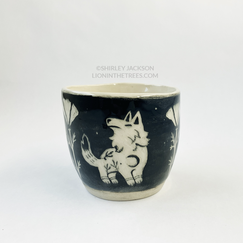 Photo of my black sgraffito planter that features my Keeper Wolves motif and poppies