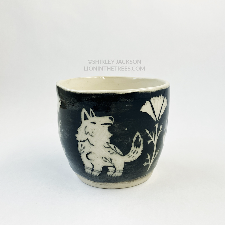 Photo of my black sgraffito planter that features my Keeper Wolves motif and poppies