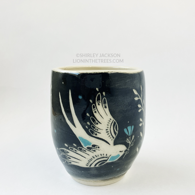 Photo of my black sgraffito cylindrical vessel featuring my new swallow motif with turquoise details