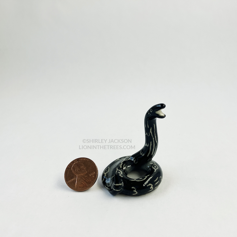Photo of my little snake totem pictured next to a penny for scale
