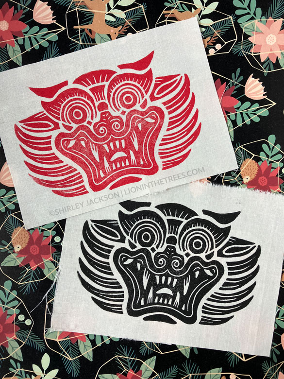 Lino block print on cream fabric featuring the Dokkaebi. A red print and black print are featured in this photo.