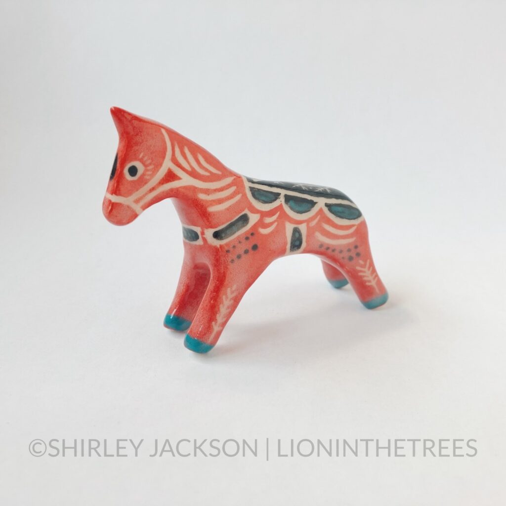 Left Side View - A ceramic sgraffito horse totem with red, black, and turquoise underglaze. Features a California Poppy design.