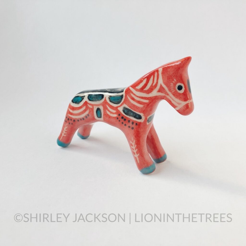 Right Side View - A ceramic sgraffito horse totem with red, black, and turquoise underglaze. Features a California Poppy design.
