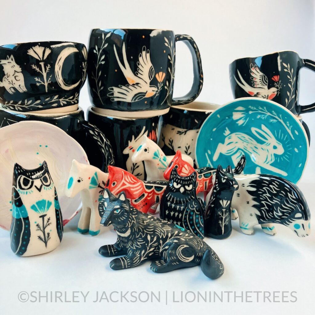 Group photo of my latest pottery. Features a variety mugs with black sgraffito designs consisting of my running horse, keeper wolves, and new swallow motif. There are also owl, wolf, lion, and horse totems.
