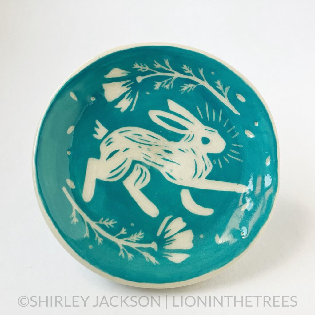 Front View - Ceramic sgraffito trinket dish with turquoise underglaze featuring my rabbit with poppies motif.