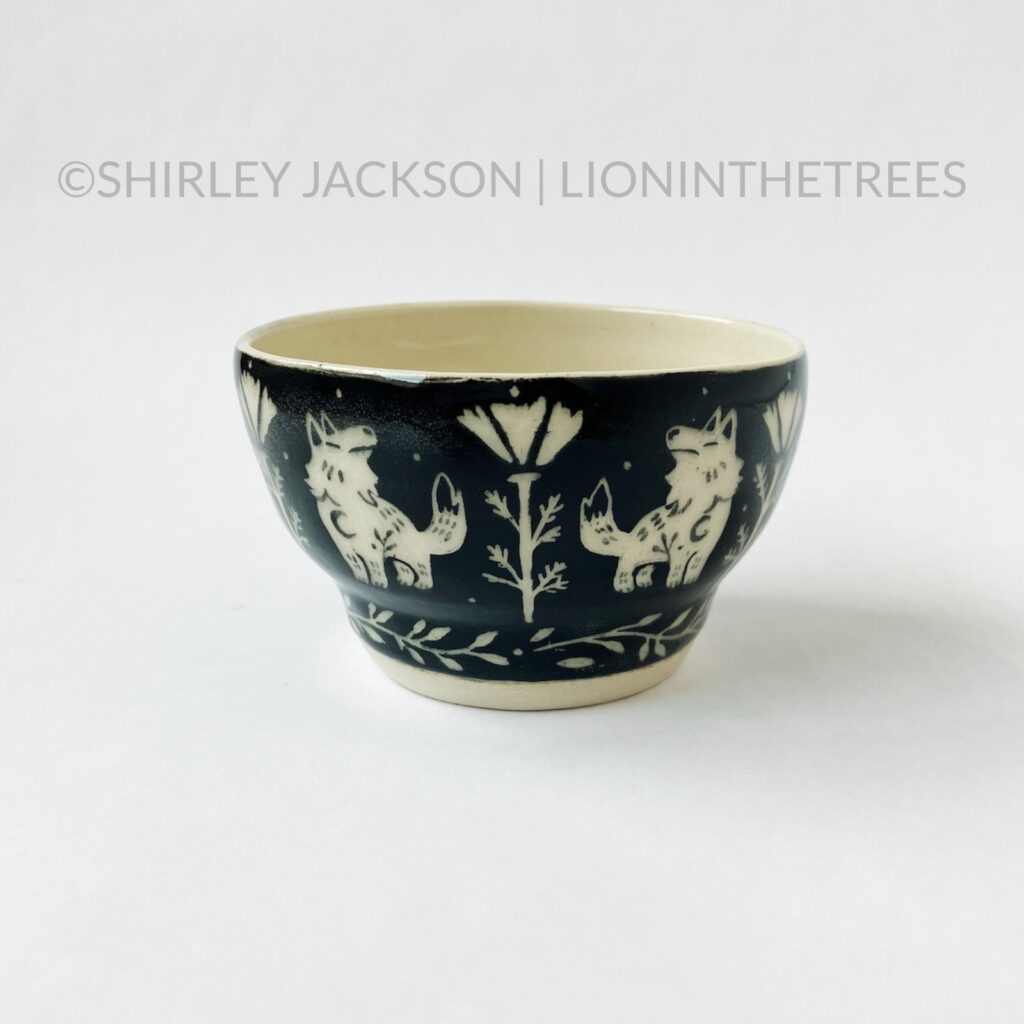 Front View - Ceramic sgraffito bowl with black underglaze featuring my Keeper Wolves motif.