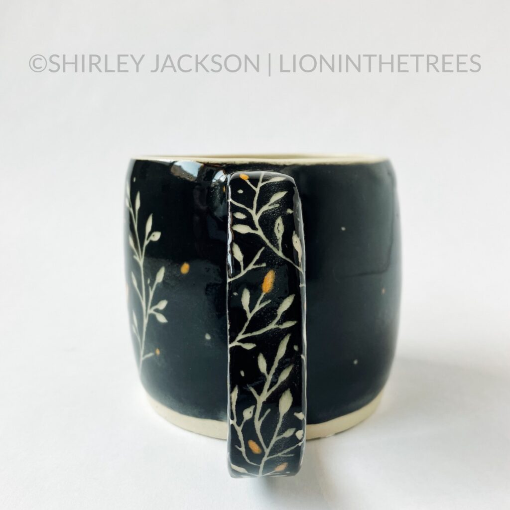 Handle View - Ceramic sgraffito mug with black and orange underglaze featuring my Barn Swallow motif. This photo highlights the floral details carved into the handle.