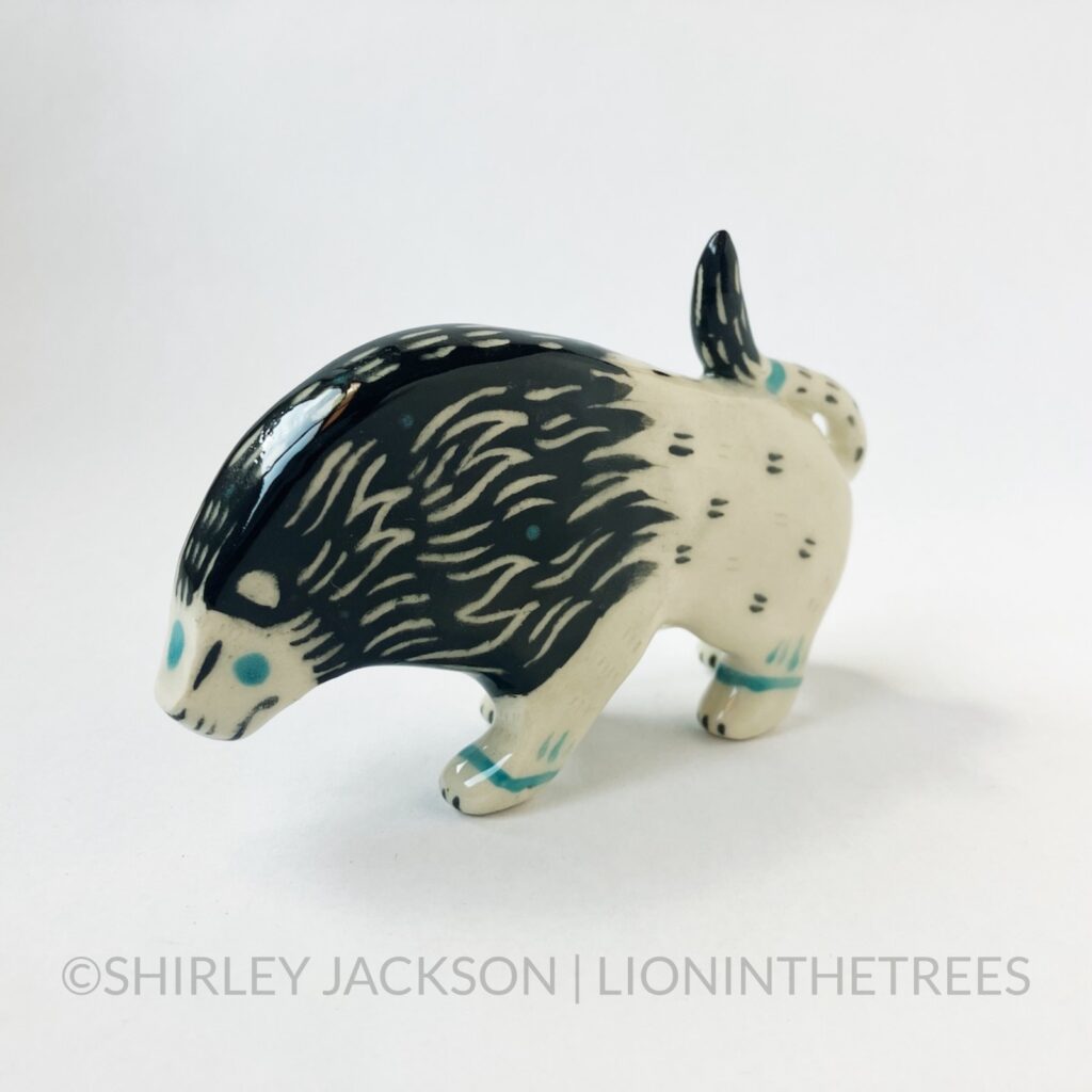 Left side view - Ceramic sgraffito lion totem with black and turquoise underglaze.