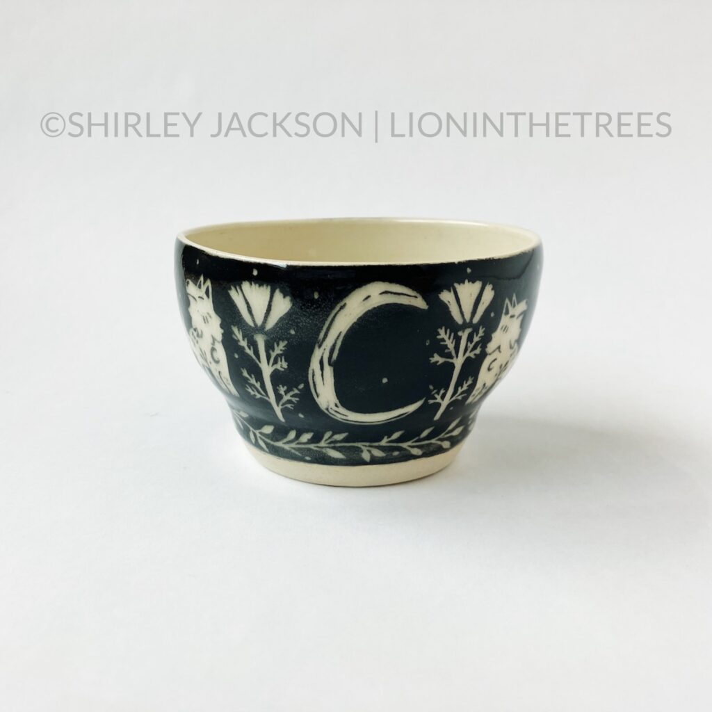 Front View - Ceramic sgraffito bowl with black underglaze featuring my Keeper Wolves motif.