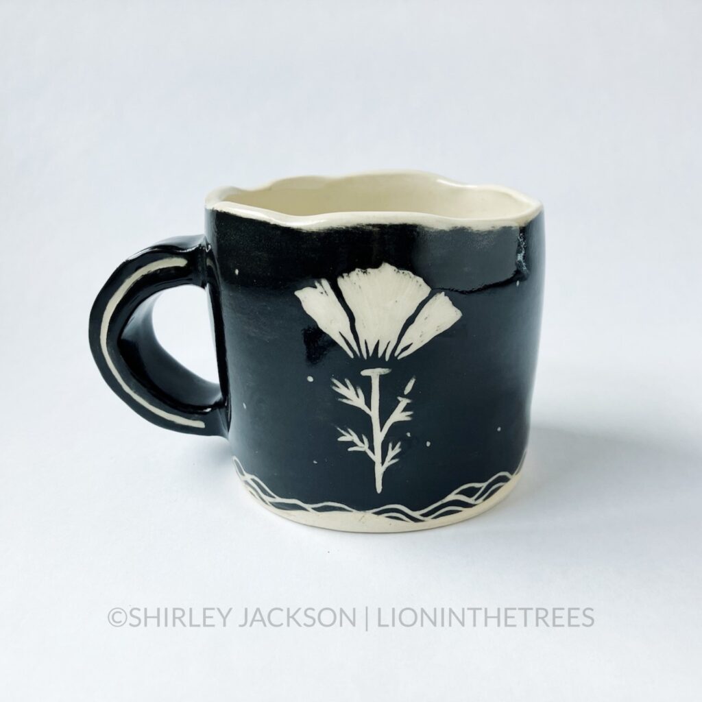 Ceramic black sgraffito mug with my swallow motif and a California Poppy motif on the back.