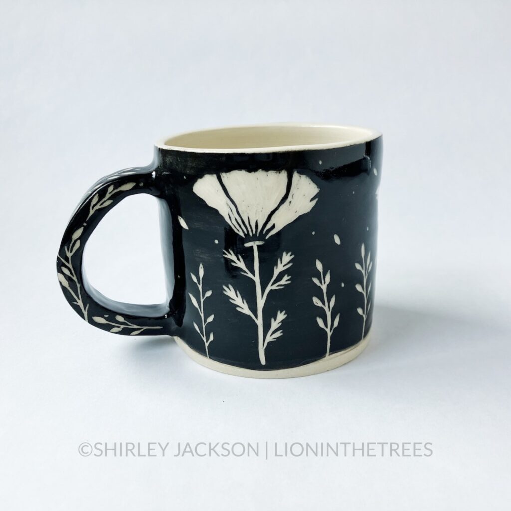 Ceramic black sgraffito mug featuring my Running Horse motif featuring a California Poppy motif on the back.