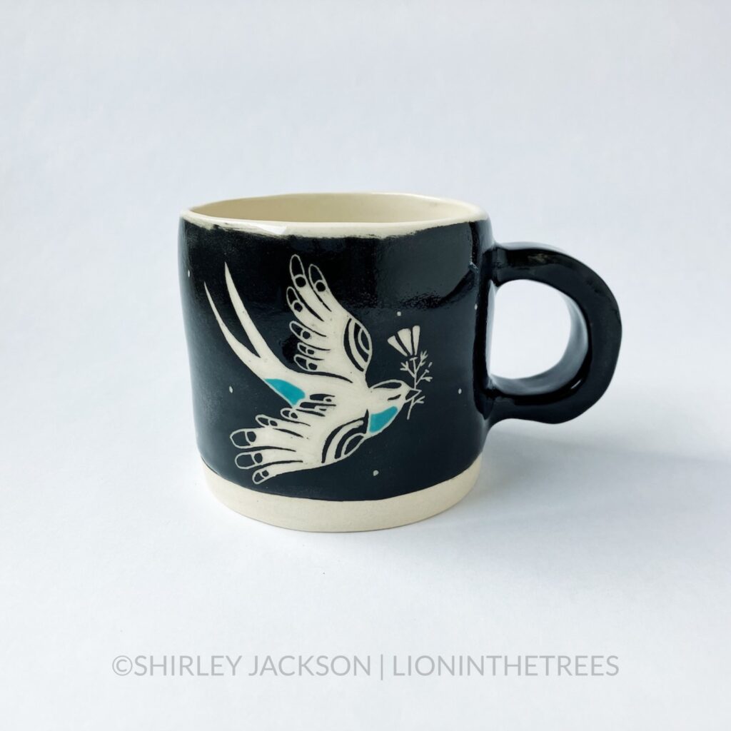 Ceramic black sgraffito mug with turquoise details featuring my swallow motif and a California Poppy motif on the back.