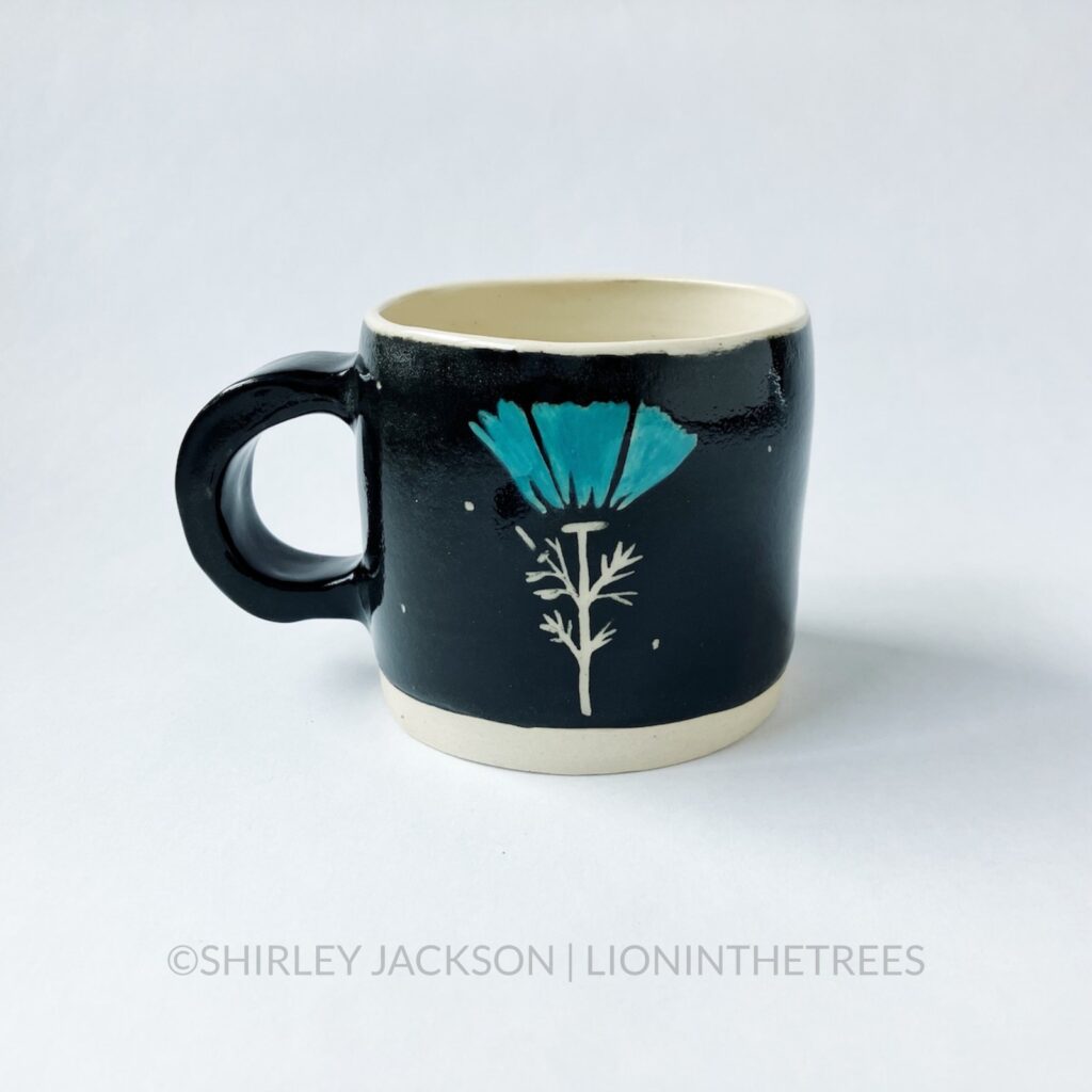 Ceramic black sgraffito mug with turquoise details featuring my swallow motif and a California Poppy motif on the back.