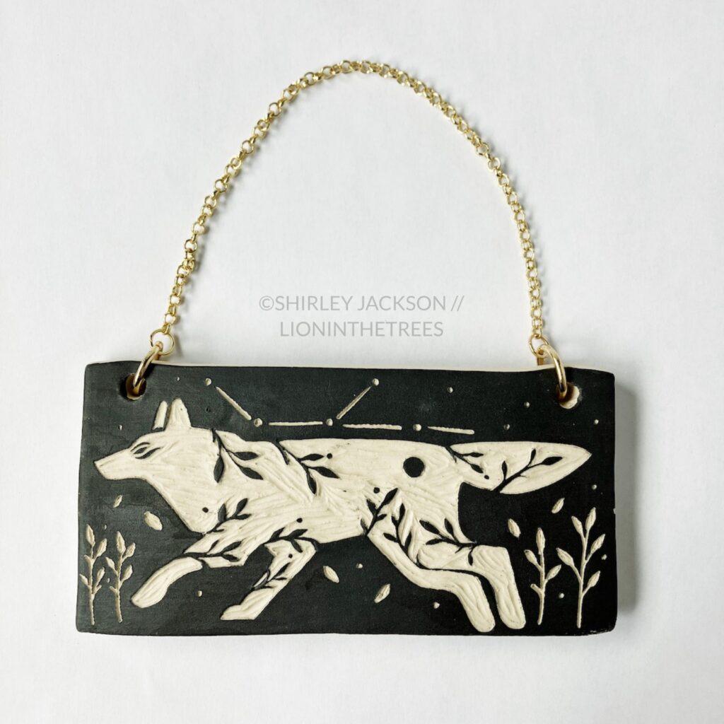 Ceramic black sgraffito wall slab featuring my Running Wolf motif