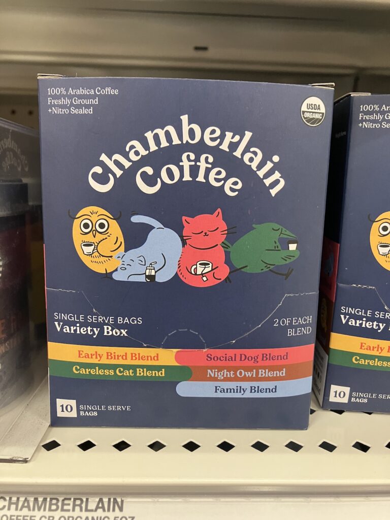 Photo of a box of single serve bags of coffee with different flavours. The brand is called "Chamberlain Coffee", with the following flavours: Early Bird Blend, Social Dog Blend, Careless Cat Blend, Night Owl Blend, and Family Blend. There are 4 different characters with coffee cups on the box as well. There's a yellow owl, a light blue dog, a red cat, and a green bird.