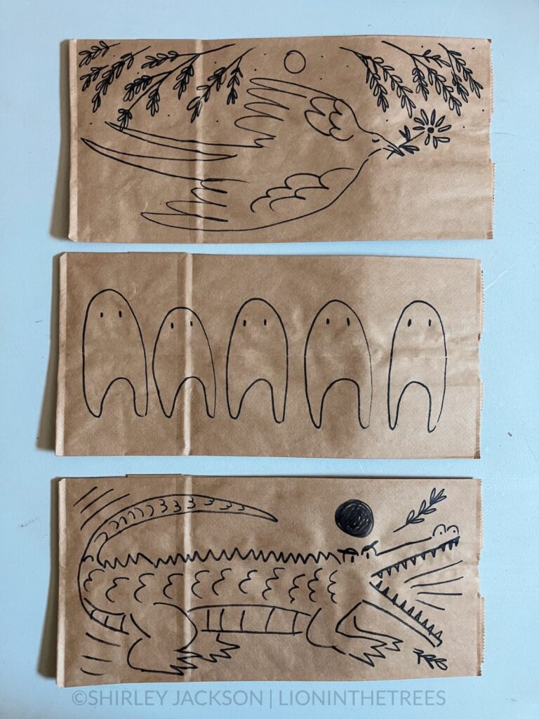 A photo of 3 brown paper lunch bags with a variety of doodles drawn with a sharpie on them. This variety features subject matter such as a Barn Swallow, the Fresno Nightcrawlers, and a crocodile.