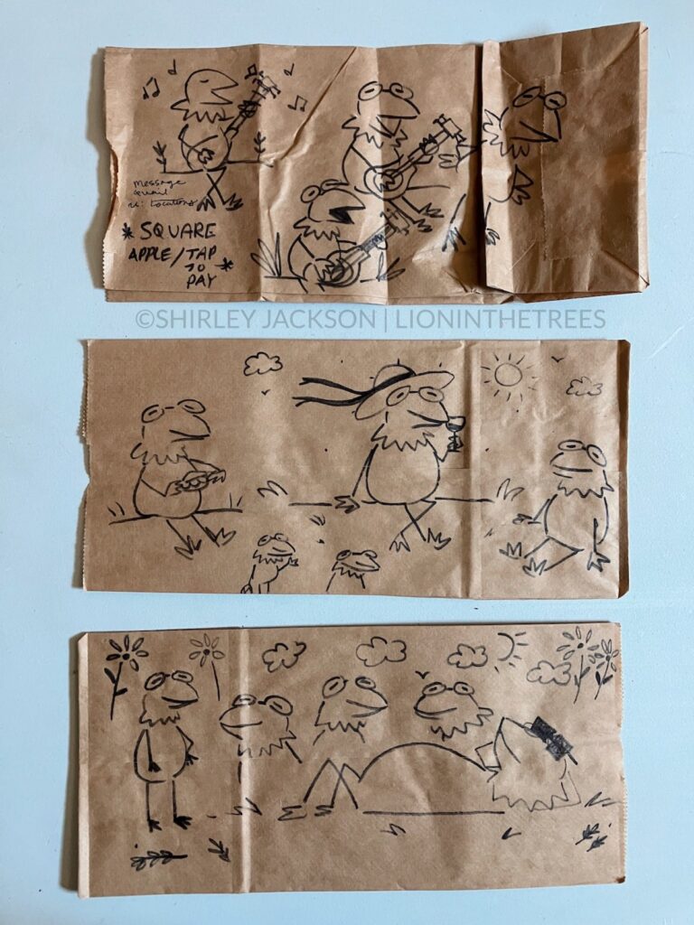 A photo of 3 brown paper lunch bags with a variety of doodles drawn with a sharpie on them. This variety features Kermit the Frog doing various activities such as sipping wine, eating a hamburger, and playing his guitar.