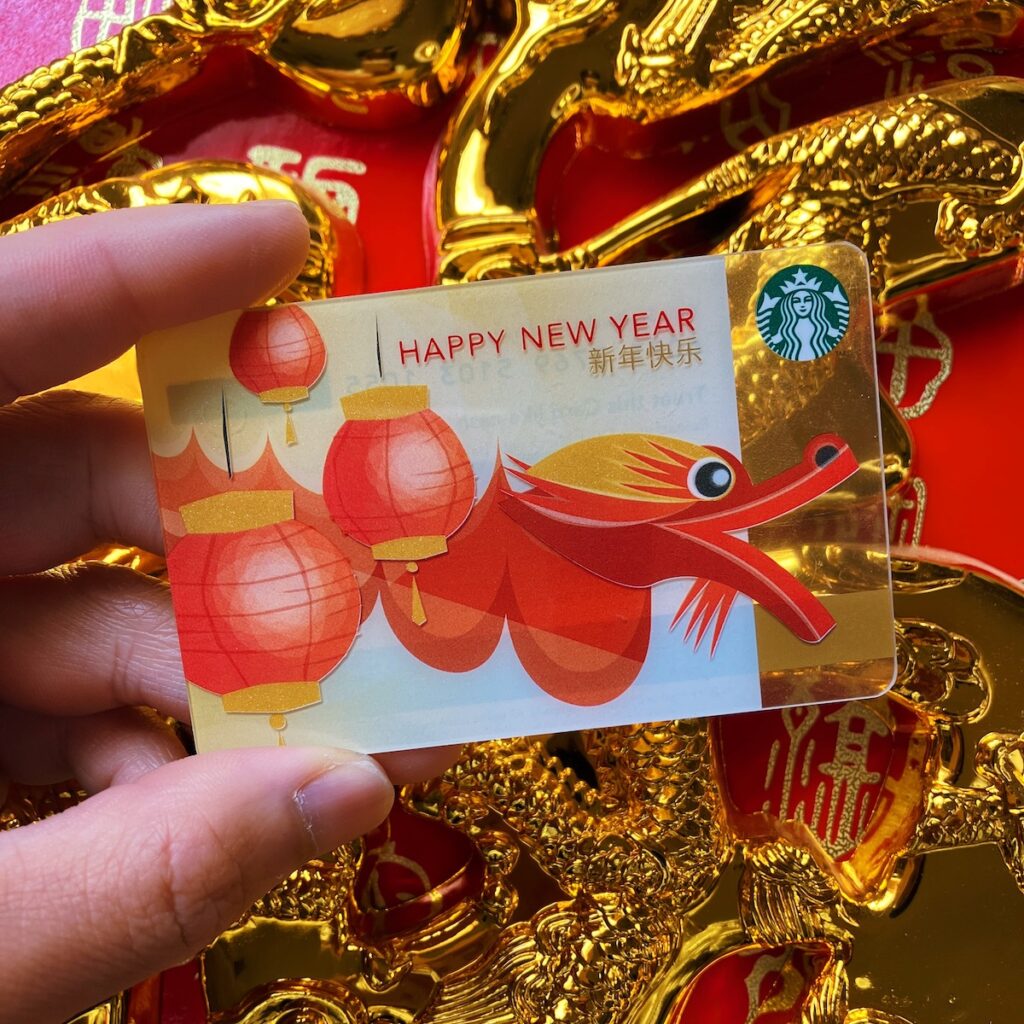 Photo of me holding a Year of the Dragon Starbucks gift card back from 2012. It has a stylised dragon with paper lanterns on the front.