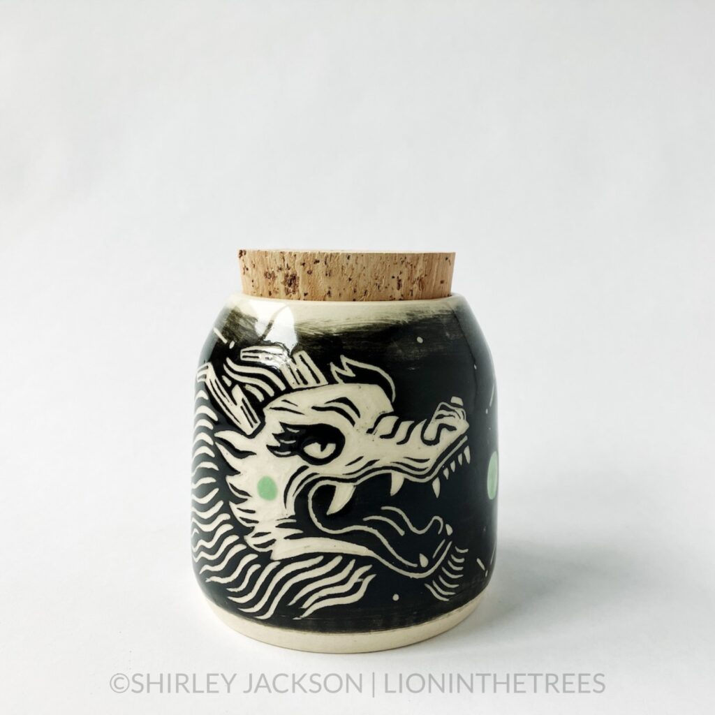 Dragon memory jar with a cork lid featuring my sgraffito dragon motif. This one was done with black and pistachio green underglaze and has constellation patterns.