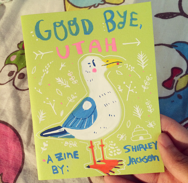 Photo of my zine dedicated to Utah that says, "Good Bye, Utah. A Zine By: Shirley Jackson".
It was done on a bright lime green cover and I painted a seagull on the cover.