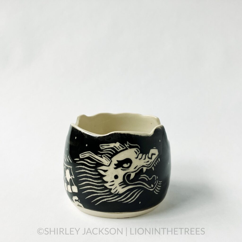 Dragon brushholder bown featuring my sgraffito dragon motif. This photo shoes the front of the bowl that shows the dragon's head.