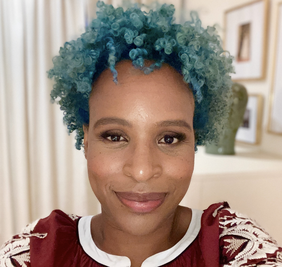 A selfie photo of Nicola Yoon where she's smizing at the camera and she's sporting these brilliant turquoise curls.