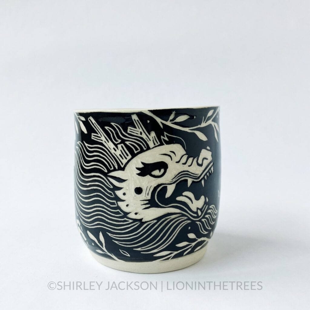Ceramic black sgraffito cylindrical vessel featuring my Year of the Dragon motif.