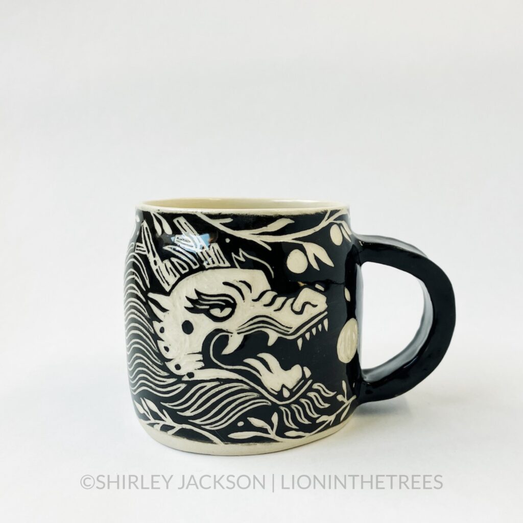 Ceramic black sgraffito mug featuring my Year of the Dragon motif.
