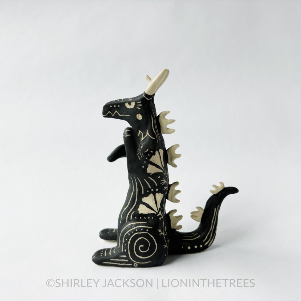 Sgraffito dragon totem with California Poppy motifs carved into it's side and chest. Done with black underglaze.