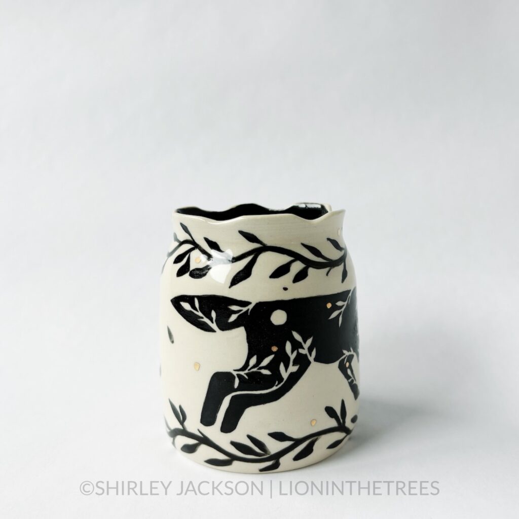 Ceramic vase featuring my Running Wolf motif. This vase also features a floral border above and below the Wolf motif.