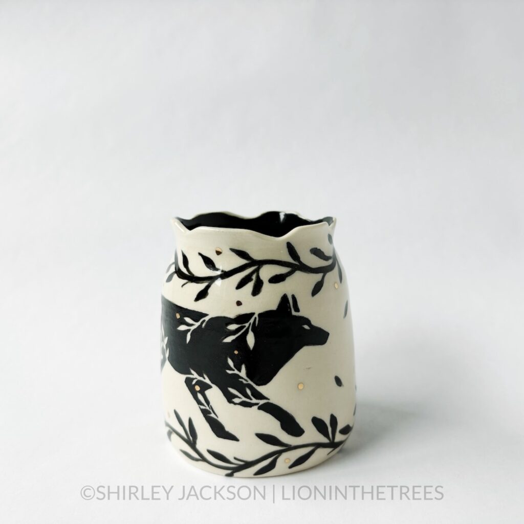 Ceramic vase featuring my Running Wolf motif. This vase also features a floral border above and below the Wolf motif.