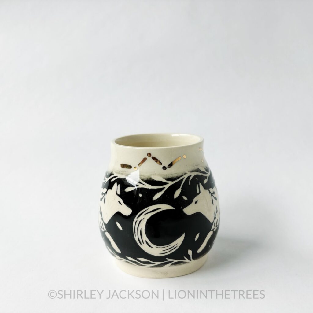 Ceramic black sgraffito vase featuring my Running Wolf motif, crescent moons, and gold luster constellation details.