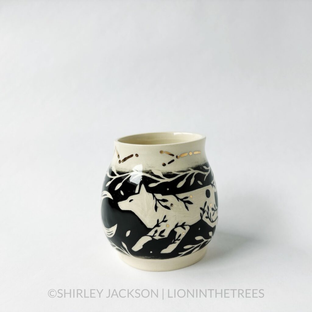 Ceramic black sgraffito vase featuring my Running Wolf motif, crescent moons, and gold luster constellation details.