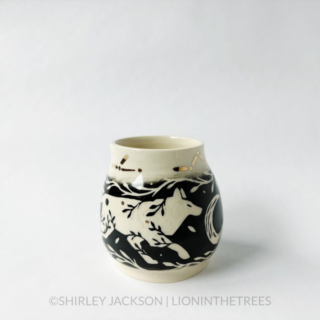 Ceramic black sgraffito vase featuring my Running Wolf motif, crescent moons, and gold luster constellation details.