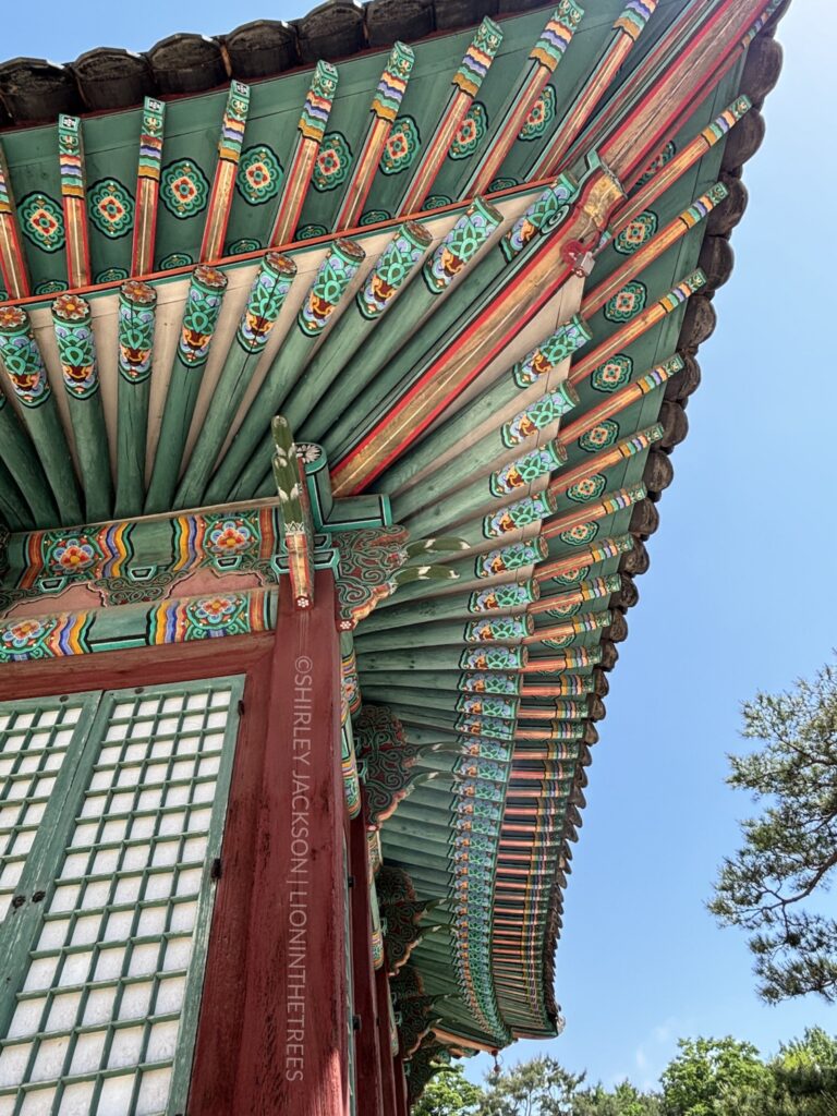 Worm's eye view of a temple. The architecture and vivid blues and reds of the building create an interesting photo taken at this particular angle.