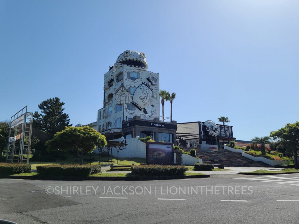 The Grimm Forest - a building found on Jeju Island that is done in a black and white cartoon style and it has a large, fearsome cartoon head on the top of the building.