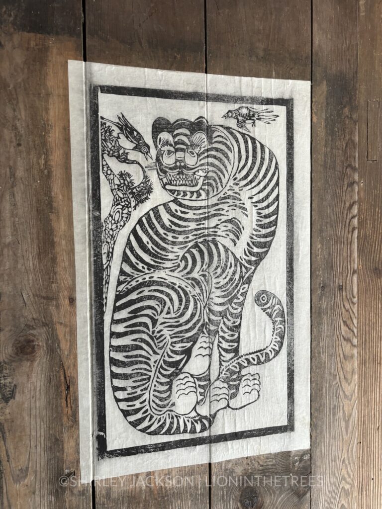 Photo of a woodblock print of a tiger with some magpie friends