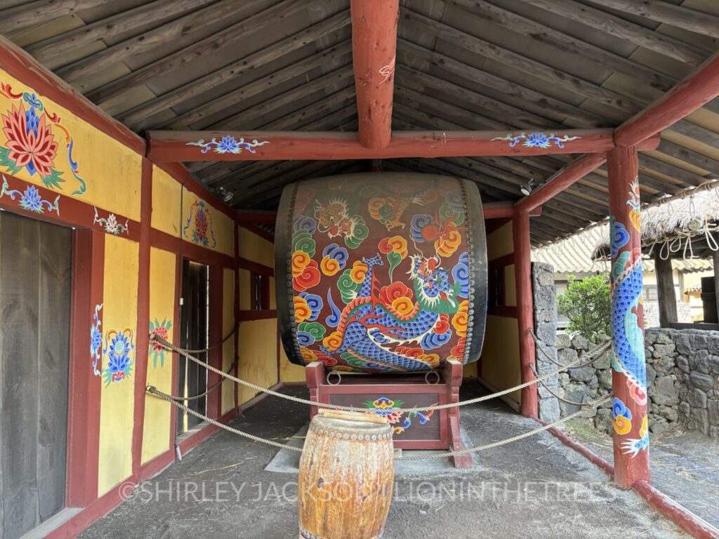 A photo of a large drum with a blue dragon painted on it's side.