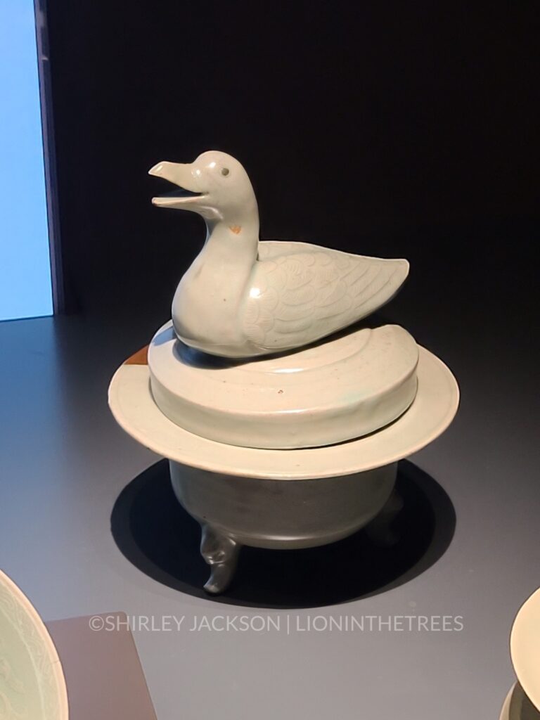 a lidded object with a duck sculpture on top of the lid