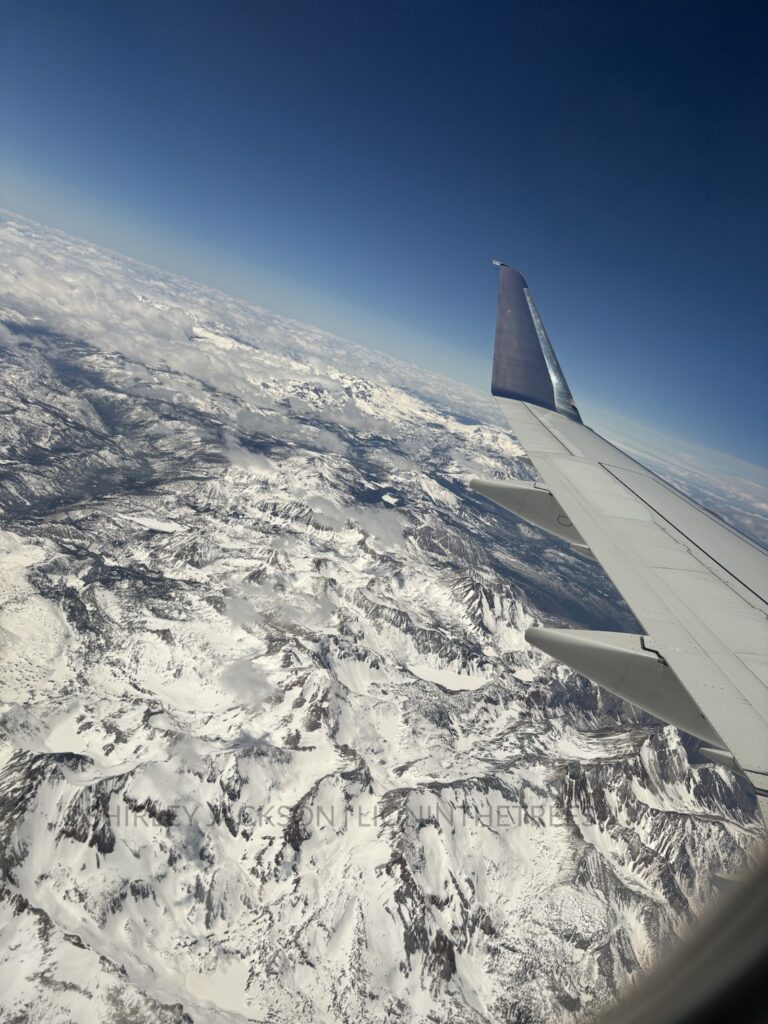 Window seat photo of snow capped mountains on my way from Fresno to Utah