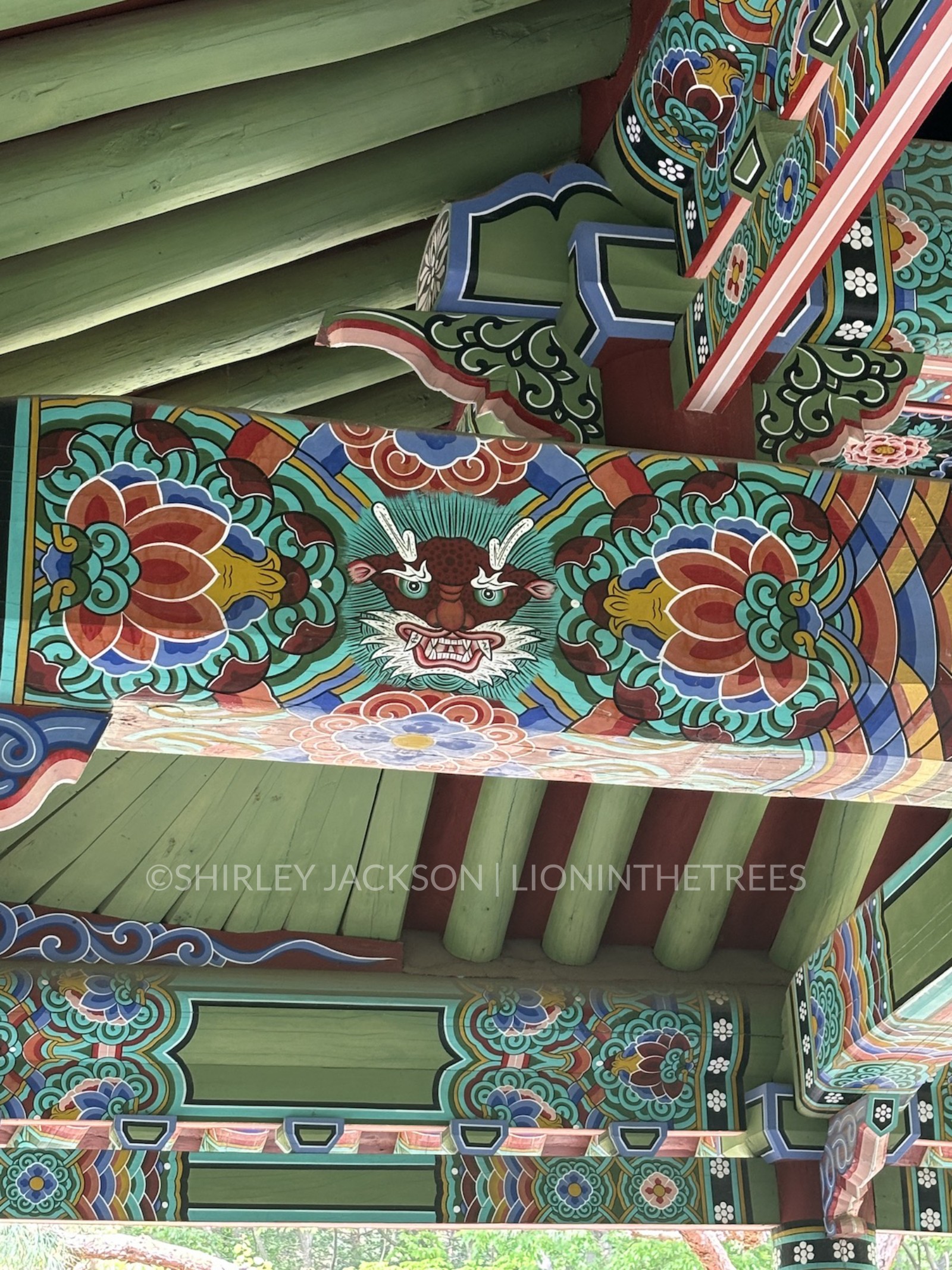 Up close photo of one of the beams inside one of the temples featuring a dragon and lotus motifs