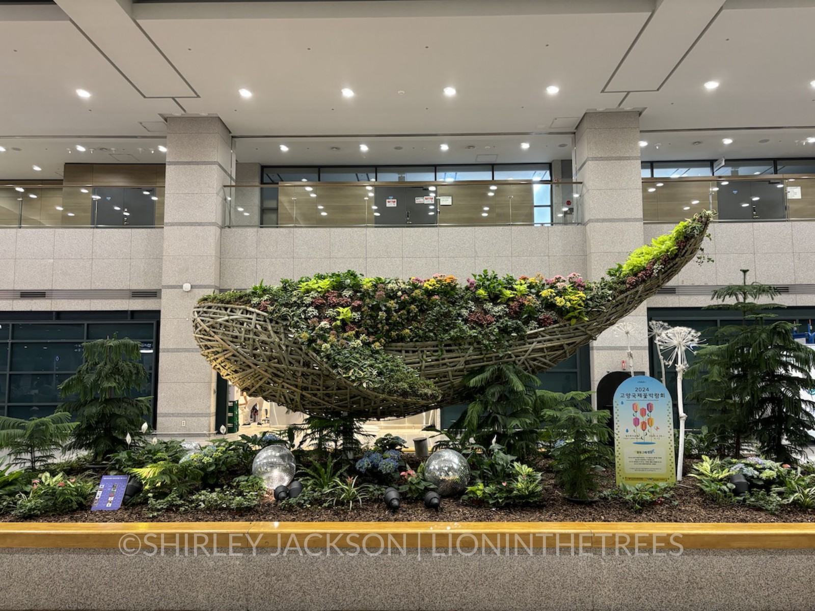 Photo of a whale sculpture created out of different flora found in Korea and wood