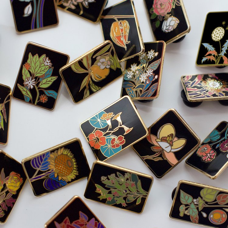 Photo of a variety of Botanica tarot card enamel pins Made by Kevin Jay Stanton