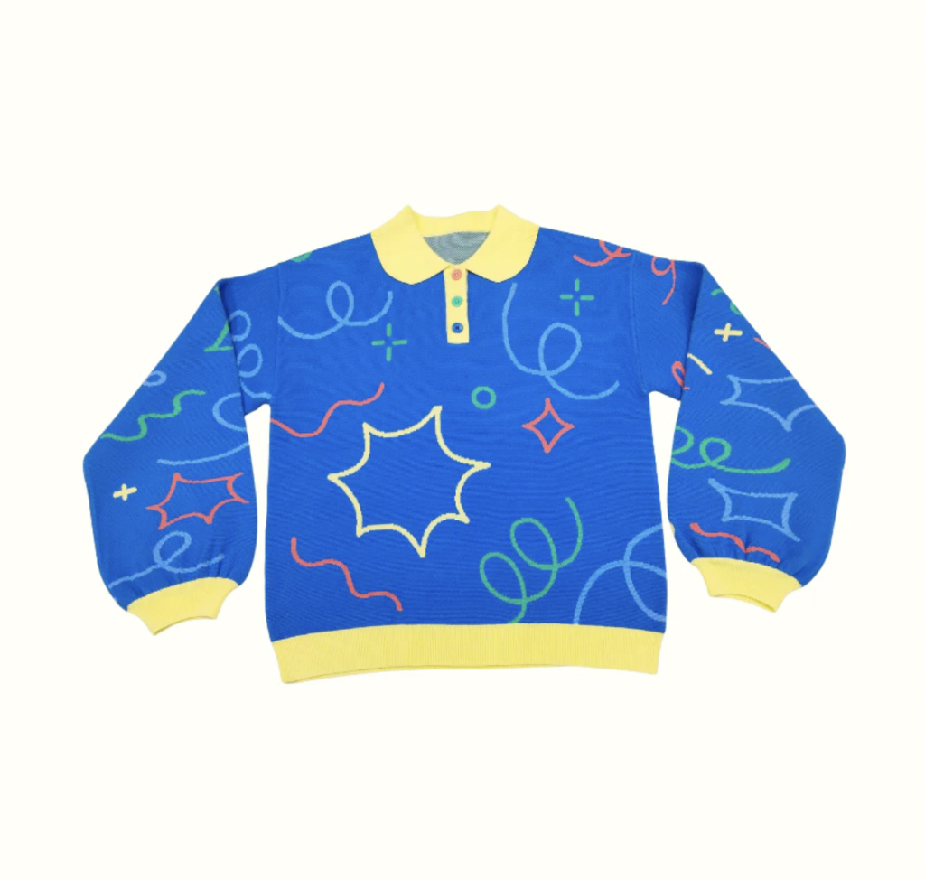 A blue and yellow sweater that features fun swirls and star shaped patterns. Made by Kojo Jojo Studio.