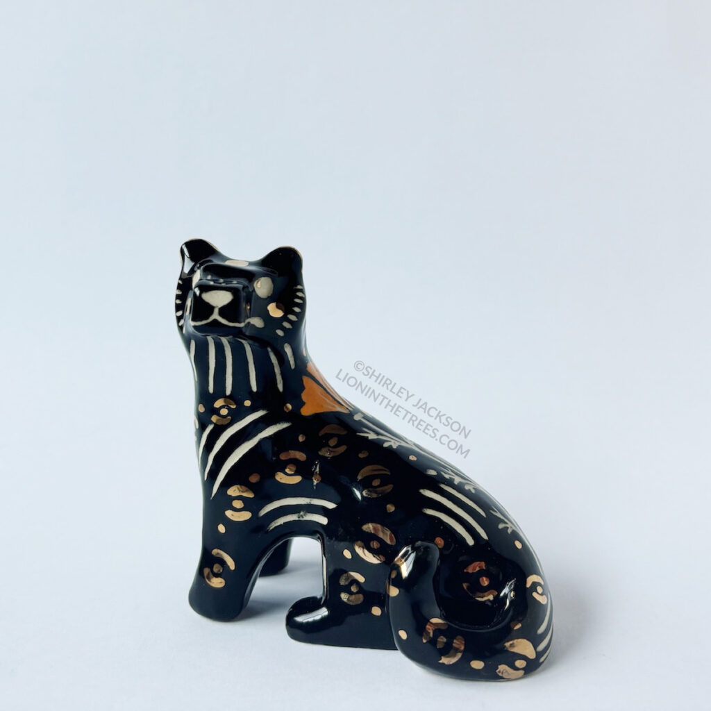 Front view of the Black Panther totem. This piece was done with orange and black underglaze, gold overglaze, and a clear glaze.