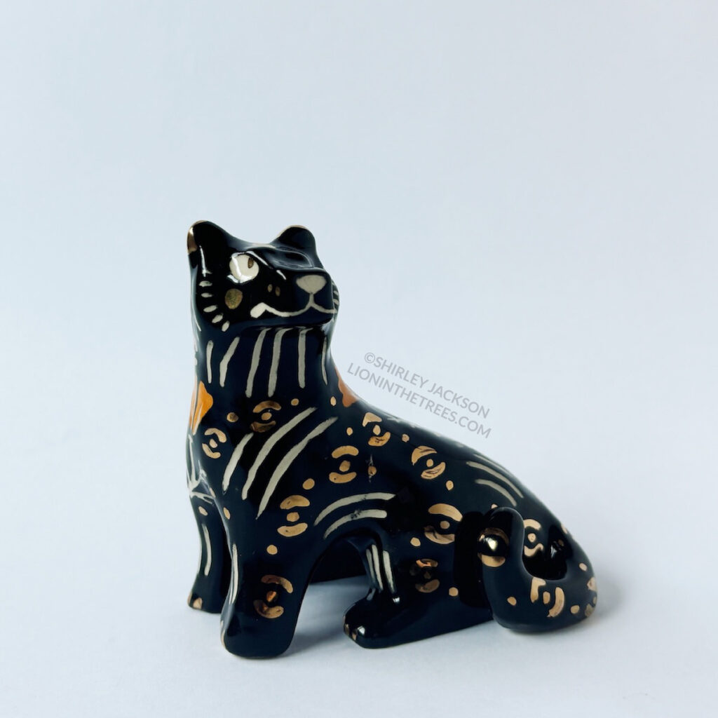 Right front view of the Black Panther totem. This piece was done with orange and black underglaze, gold overglaze, and a clear glaze.