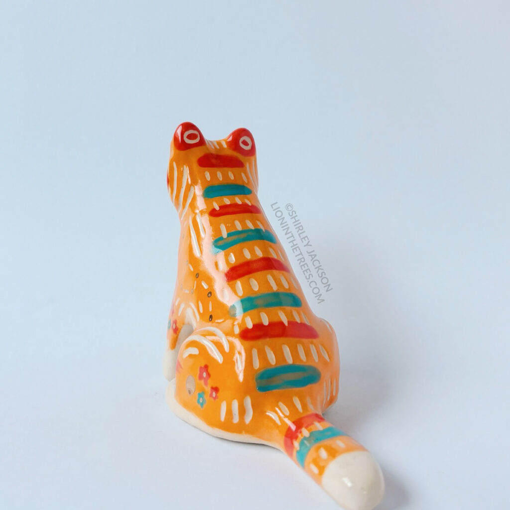 Back view of the Taekho Tiger totem. This piece was done with orange, red, and turquoise underglazes, gold overglaze, and a clear glaze.