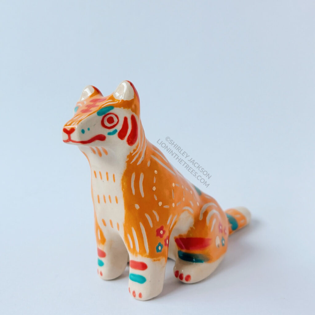 Front left view of the Taekho Tiger totem. This piece was done with orange, red, and turquoise underglazes, gold overglaze, and a clear glaze.